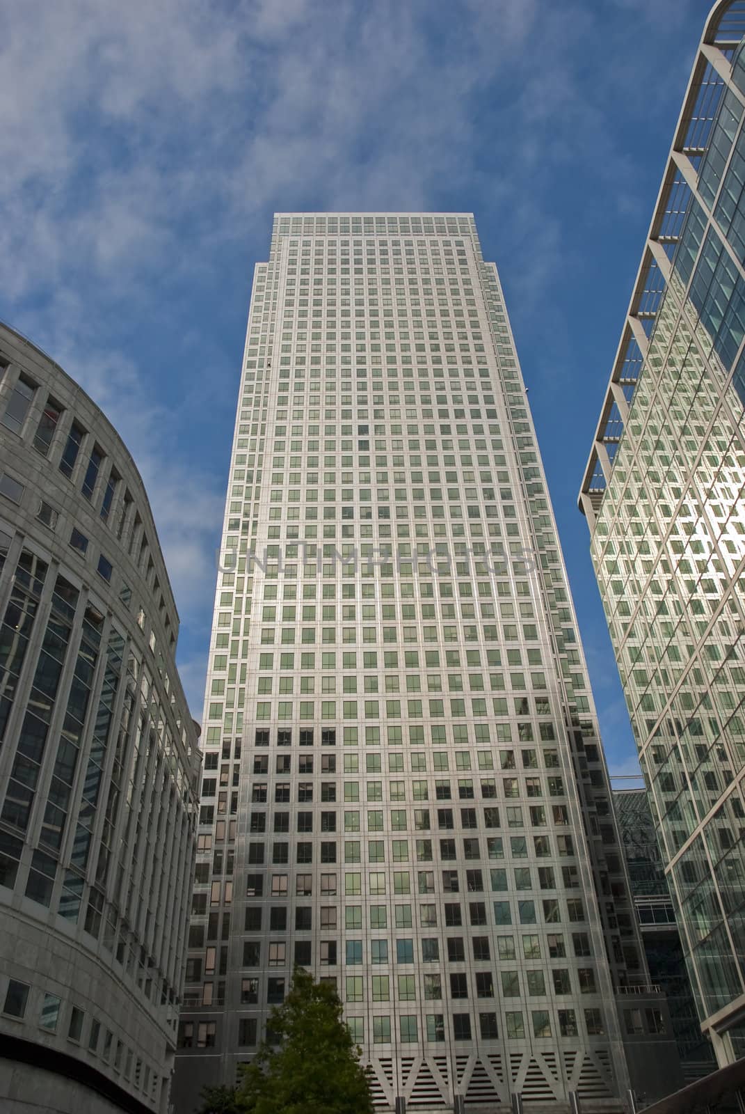 Three modern buildings reflecting the clouds in the sky