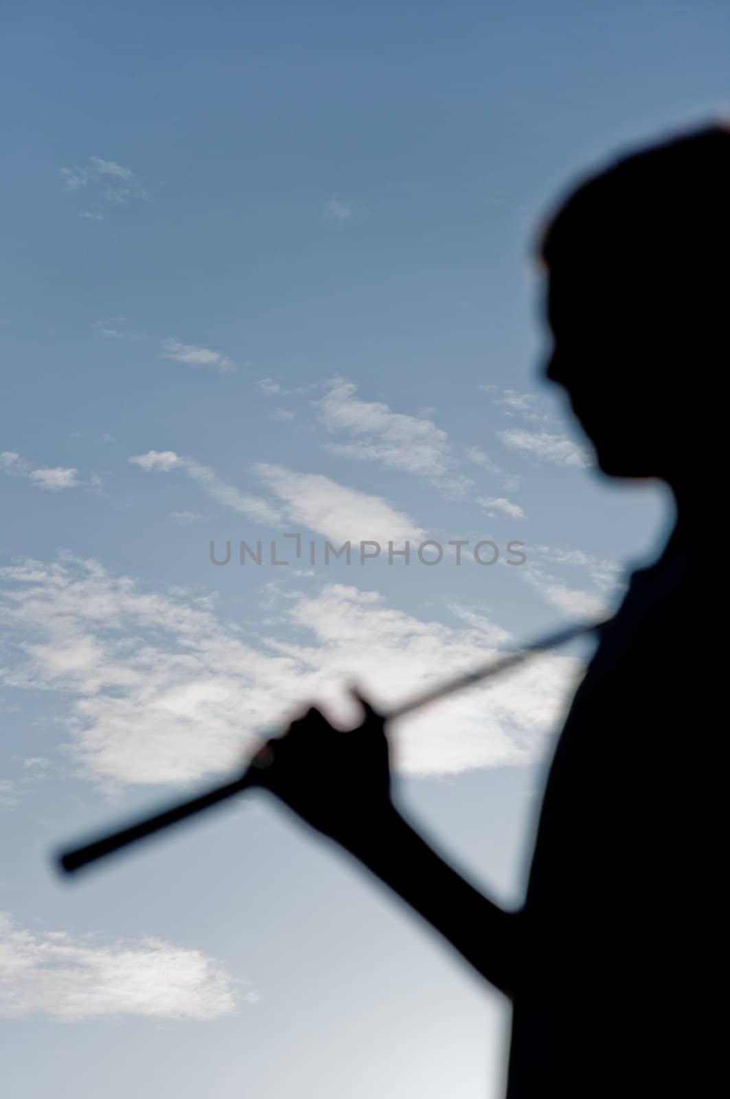 Siluette of golfer on a blue sky background with clouds