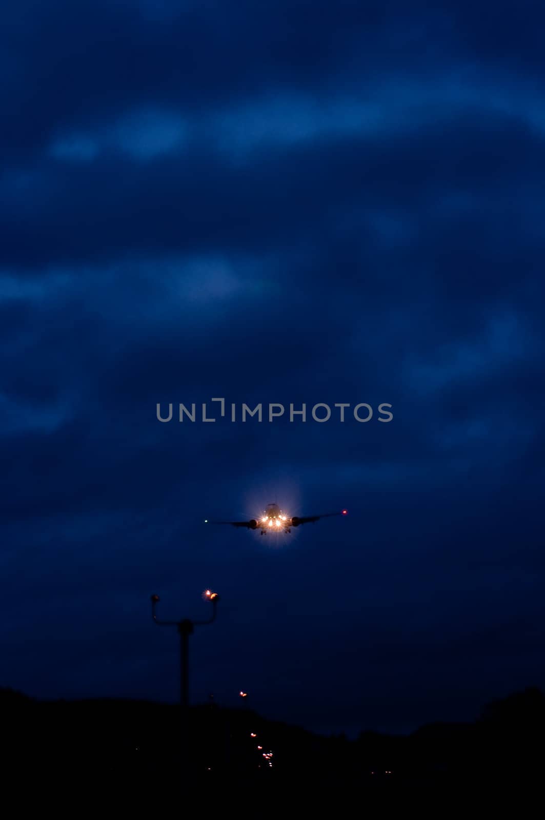 Airplane landing in the dark with the airport lights showing