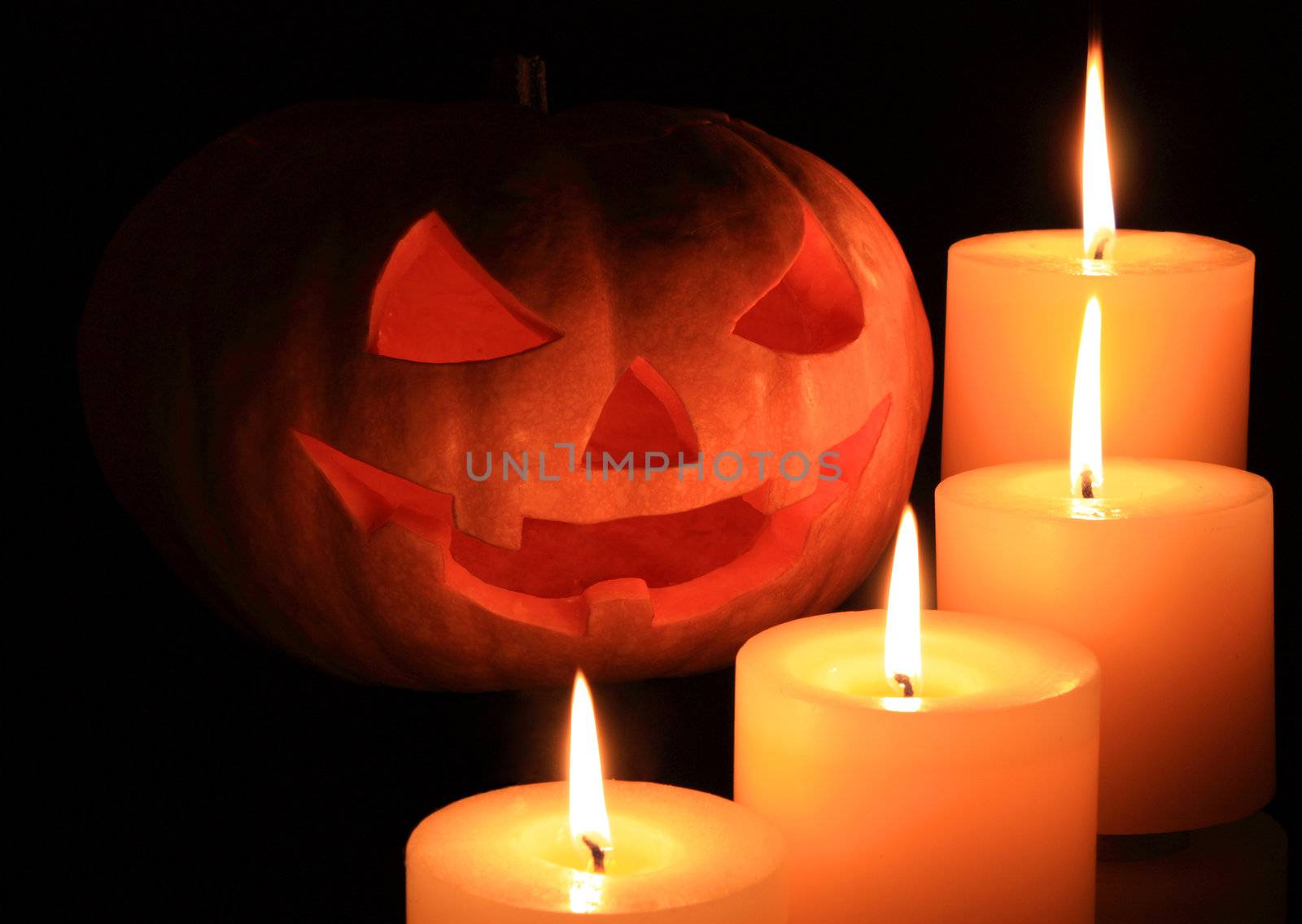 Jack o'lantern surrounded by candles