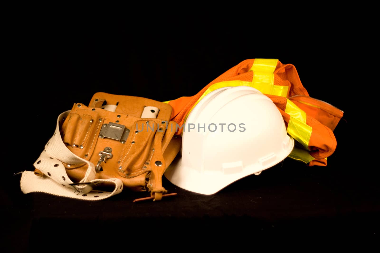 Tool Belt Construction Hard Hat Reflective Safety Vest isolated on a Black Background.