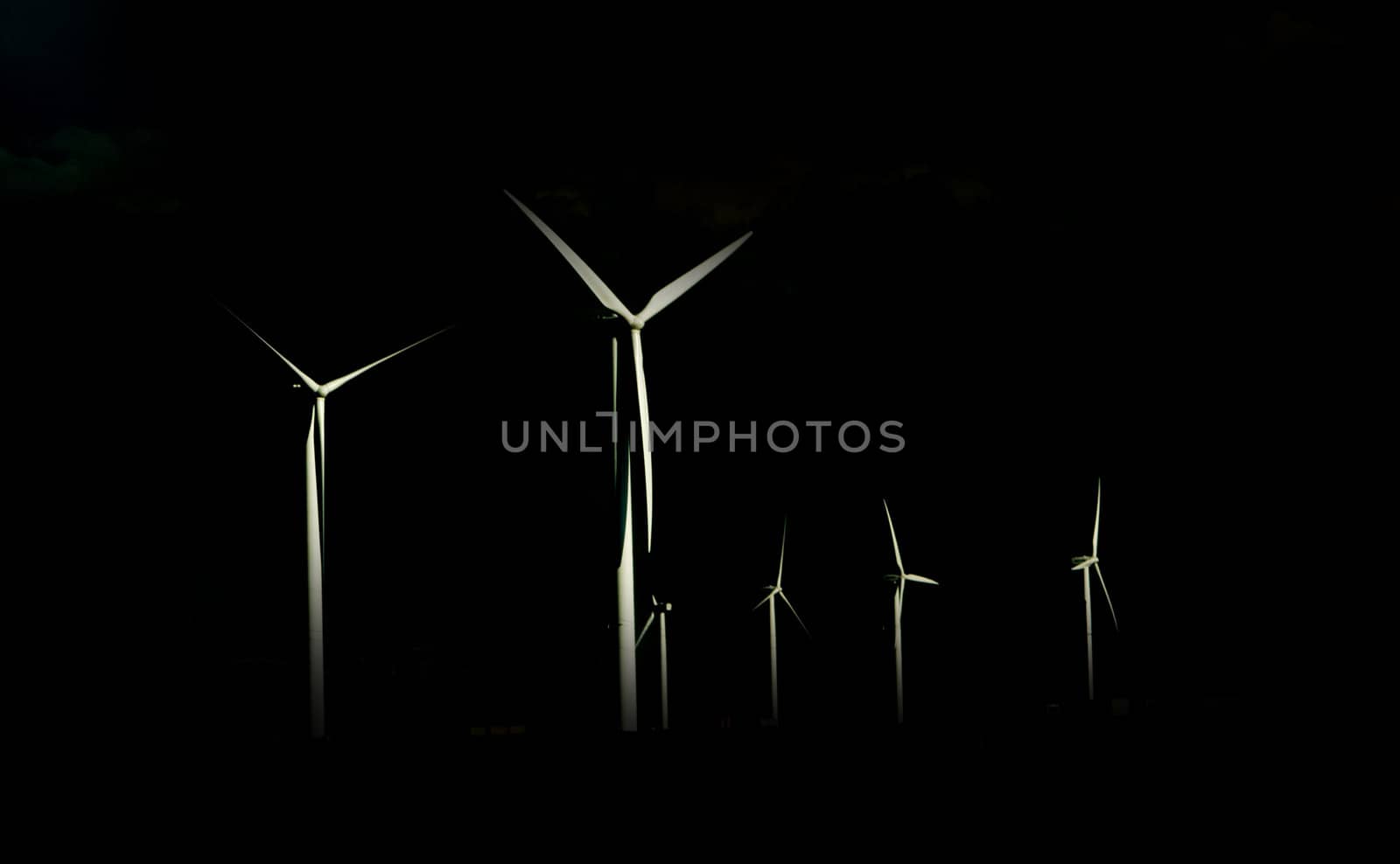 Alternative Energy Wind Power Turbines isolated against a black background.