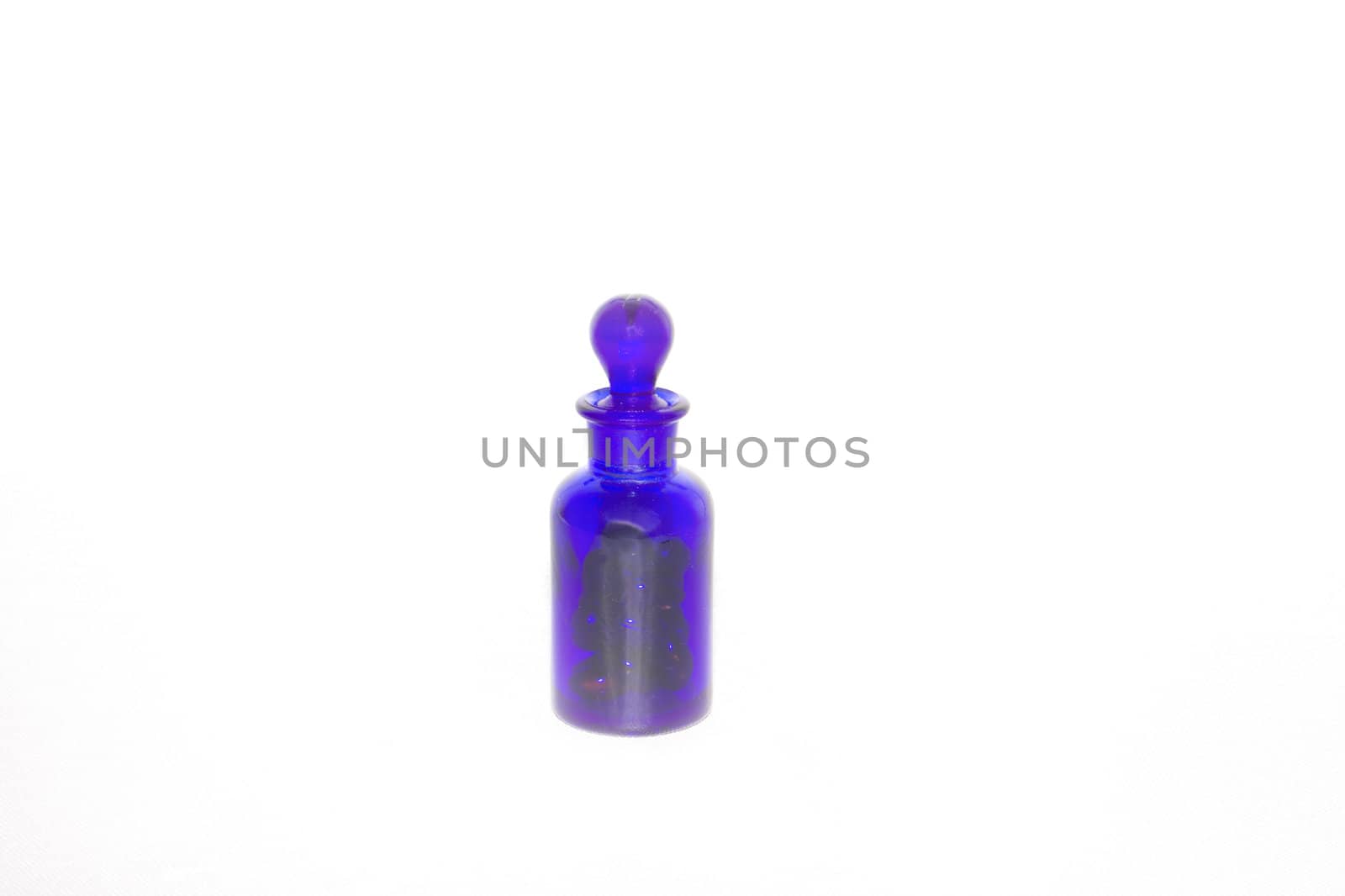 Isoalted Cobalt Blue Vial Bottle with Glass Stopper holding medicine. This type of vial is also used for perfume or essential oils for aroma therapy.