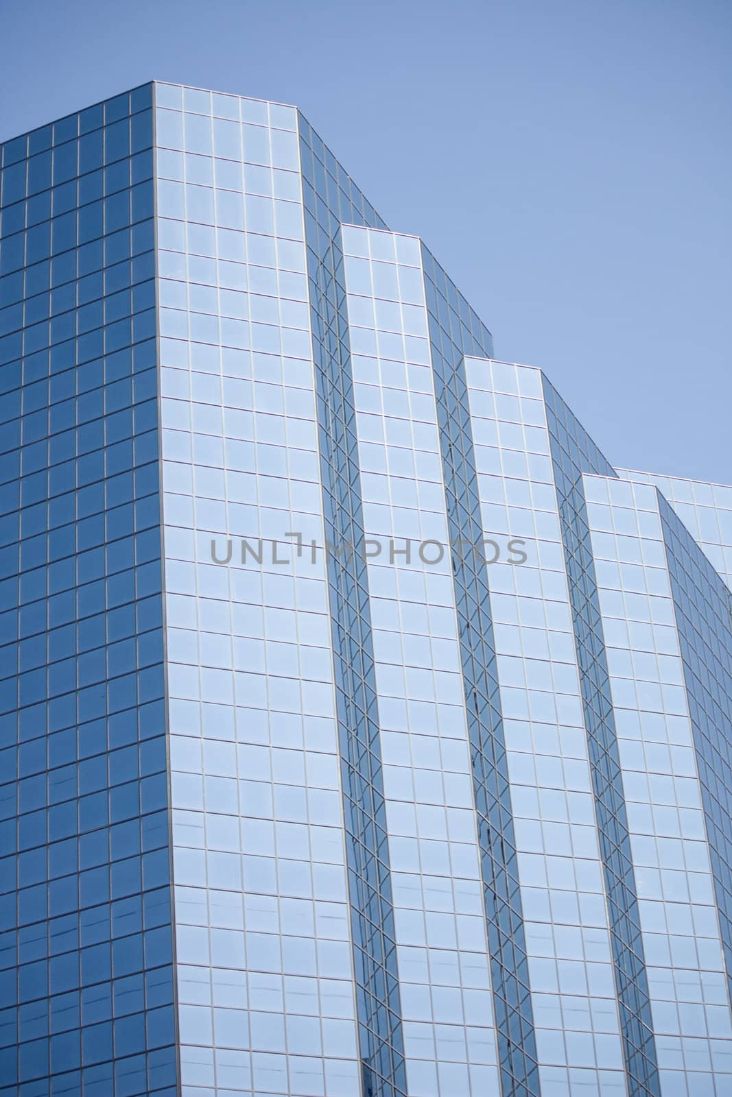 Skyscraper Glass Window Panel Office Building set against a blue sky background.