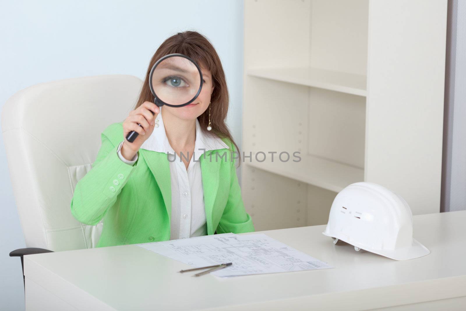 The woman the engineer looks at us through a magnifier with a smile