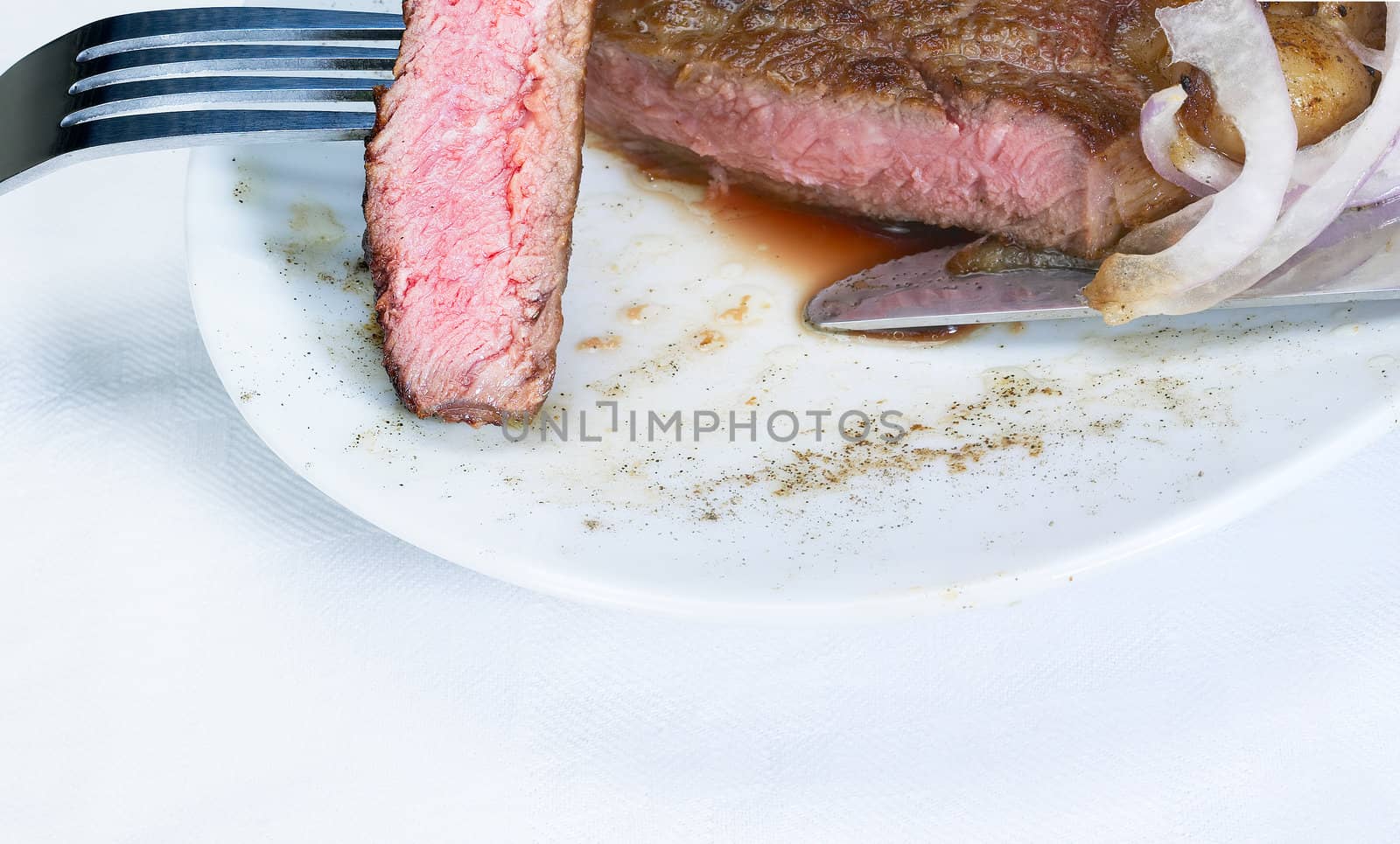 fresh juicy beef ribeye steak slice grilled with fork over a plate