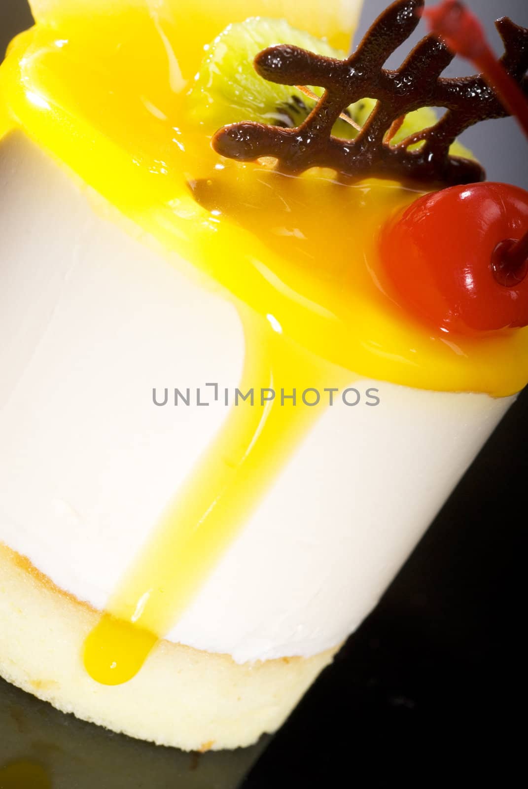 piece of fresh fruit cake close up over black reflective surface