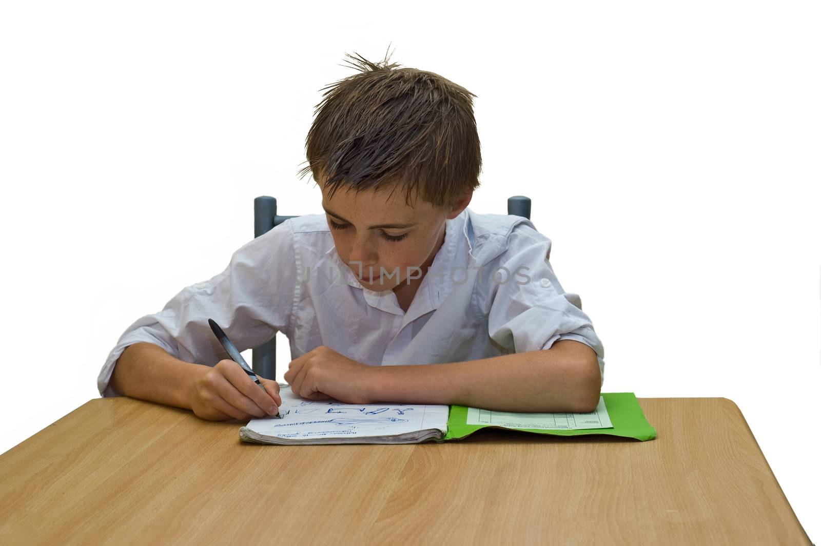 an isolated image of a teenage boy doing his school work / homework sat at a table.