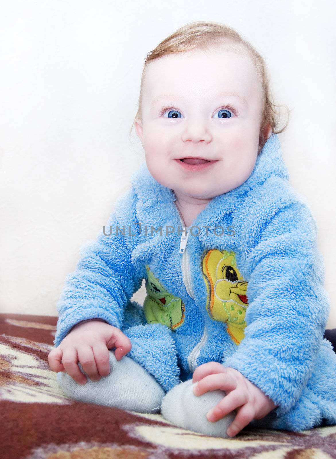 Happy baby boy sitting on sofa