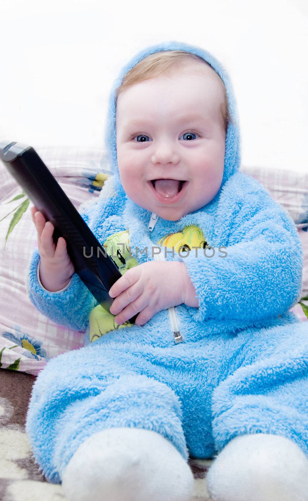 Adorable little boy holding remote control at home