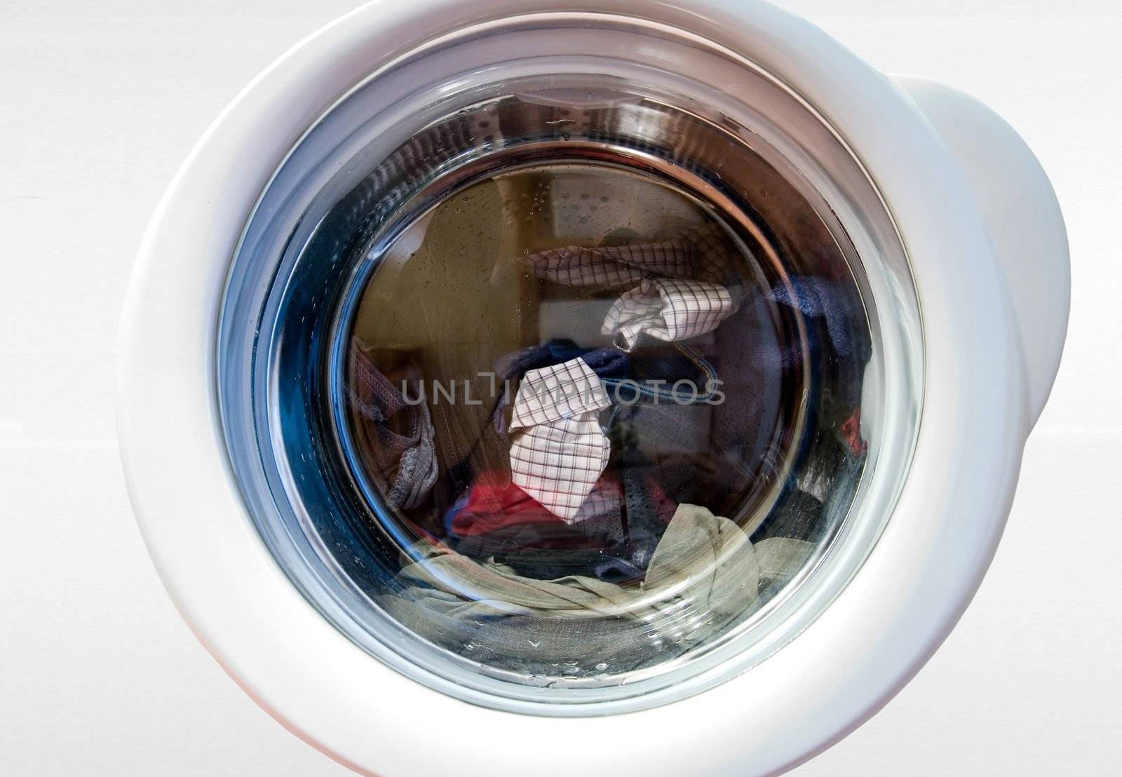 washing machine with rotating dirty loundry inside 