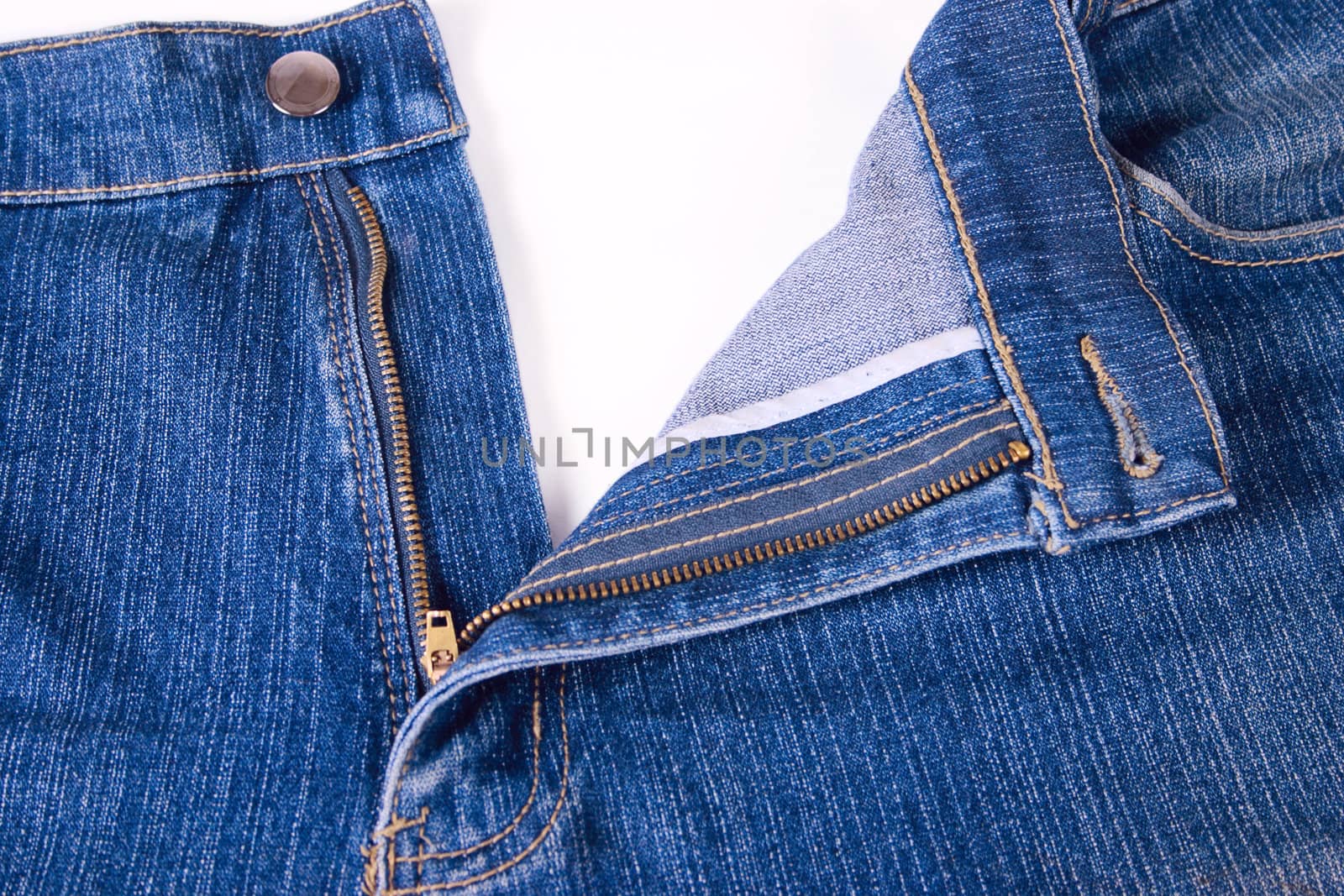 Dark blue jeans with an open fly removed close up on a white background. Are not isolated.