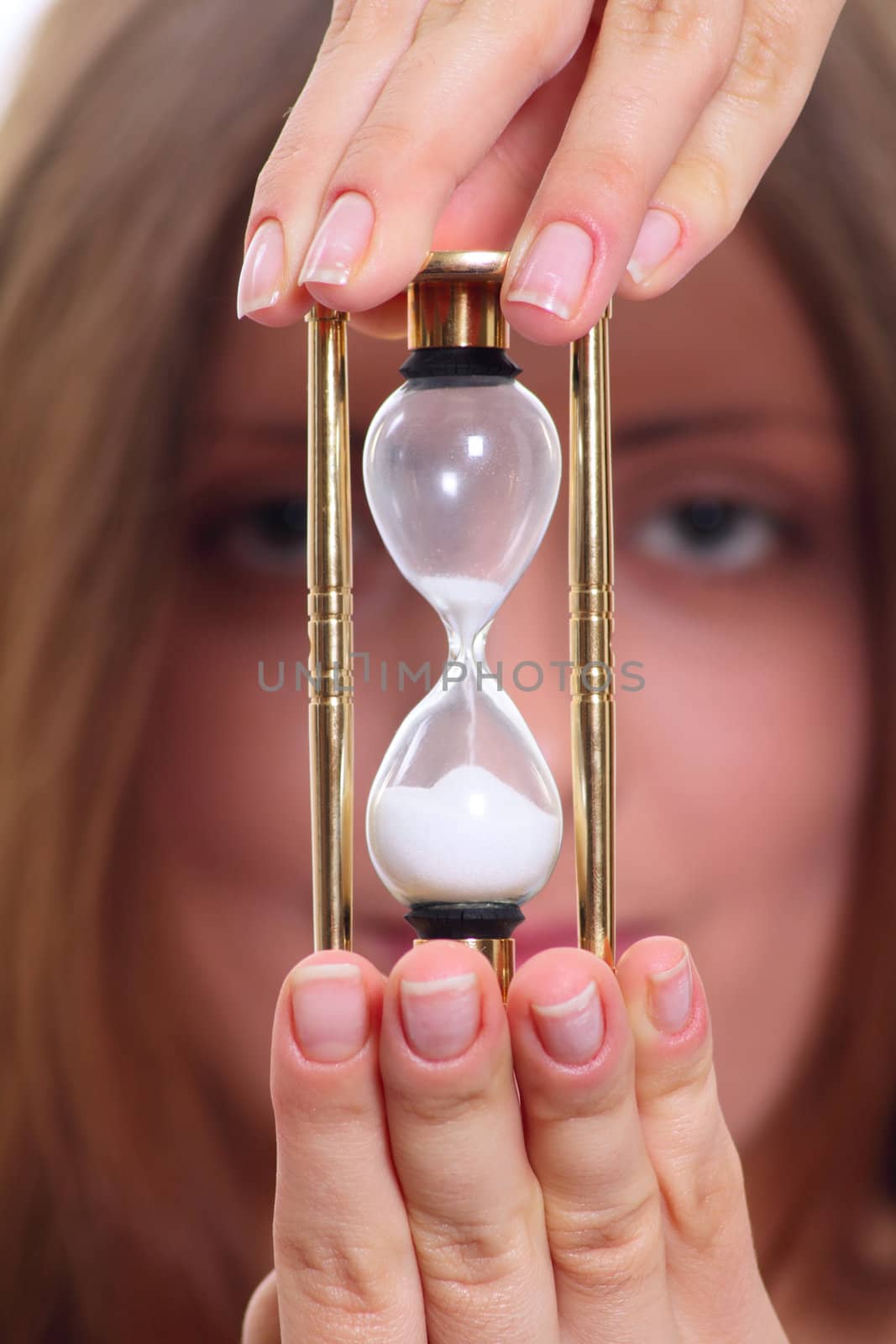 The nice girl holding a sand clock removed close up