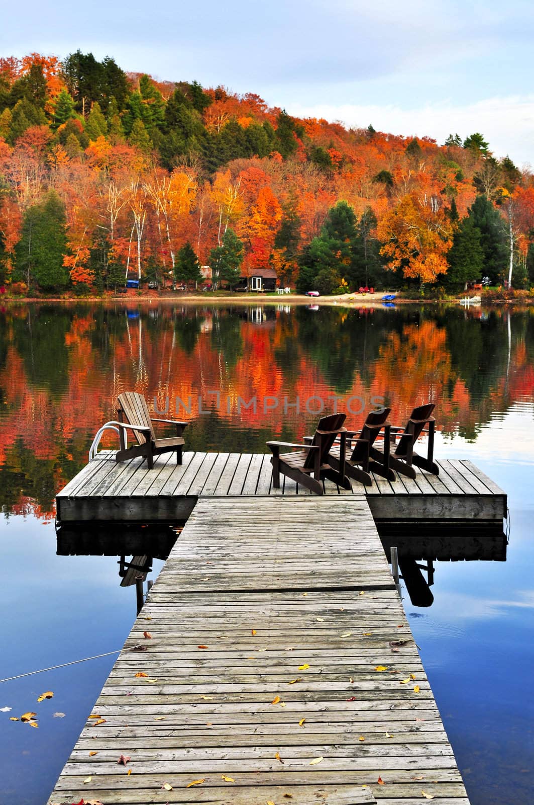 Wooden dock with chairs on calm fall lake