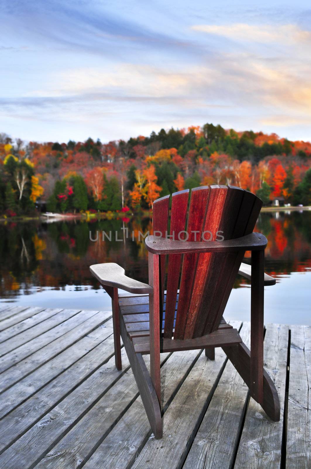 Wooden dock with chair on calm fall lake
