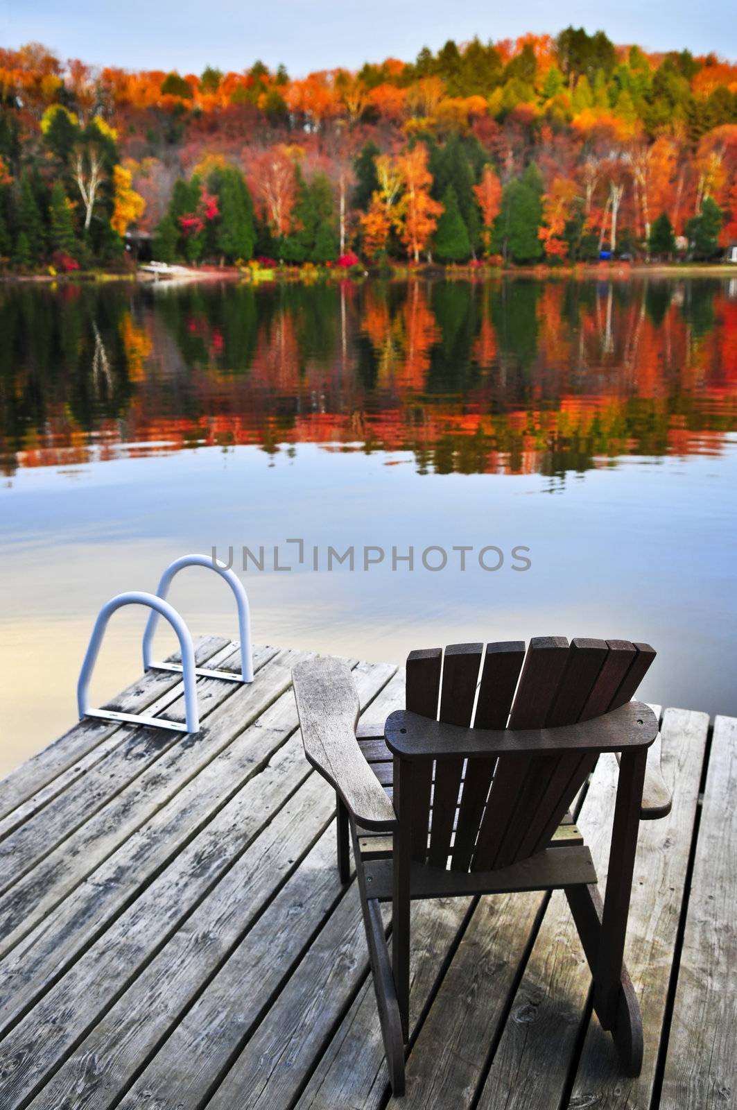 Wooden dock with chair on calm fall lake