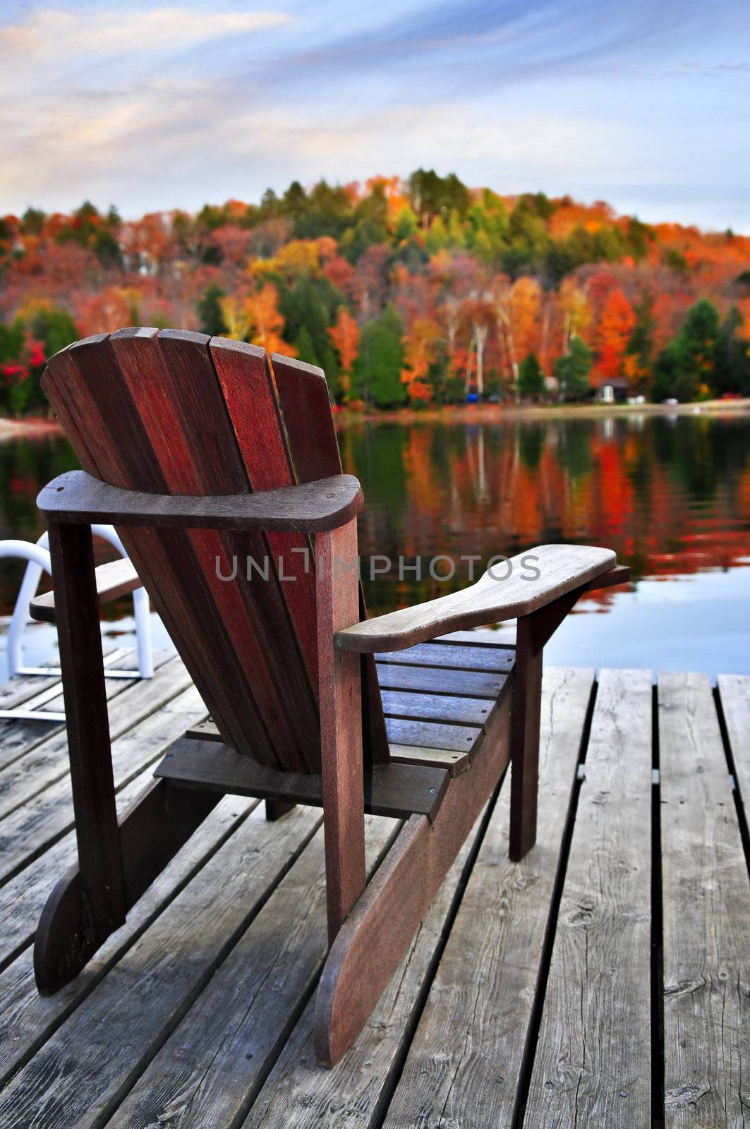 Wooden dock with chair on calm fall lake