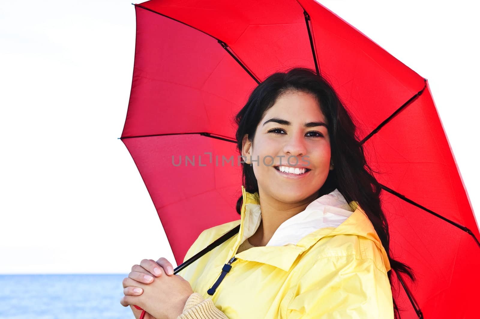 Beautiful young woman in raincoat with umbrella by elenathewise