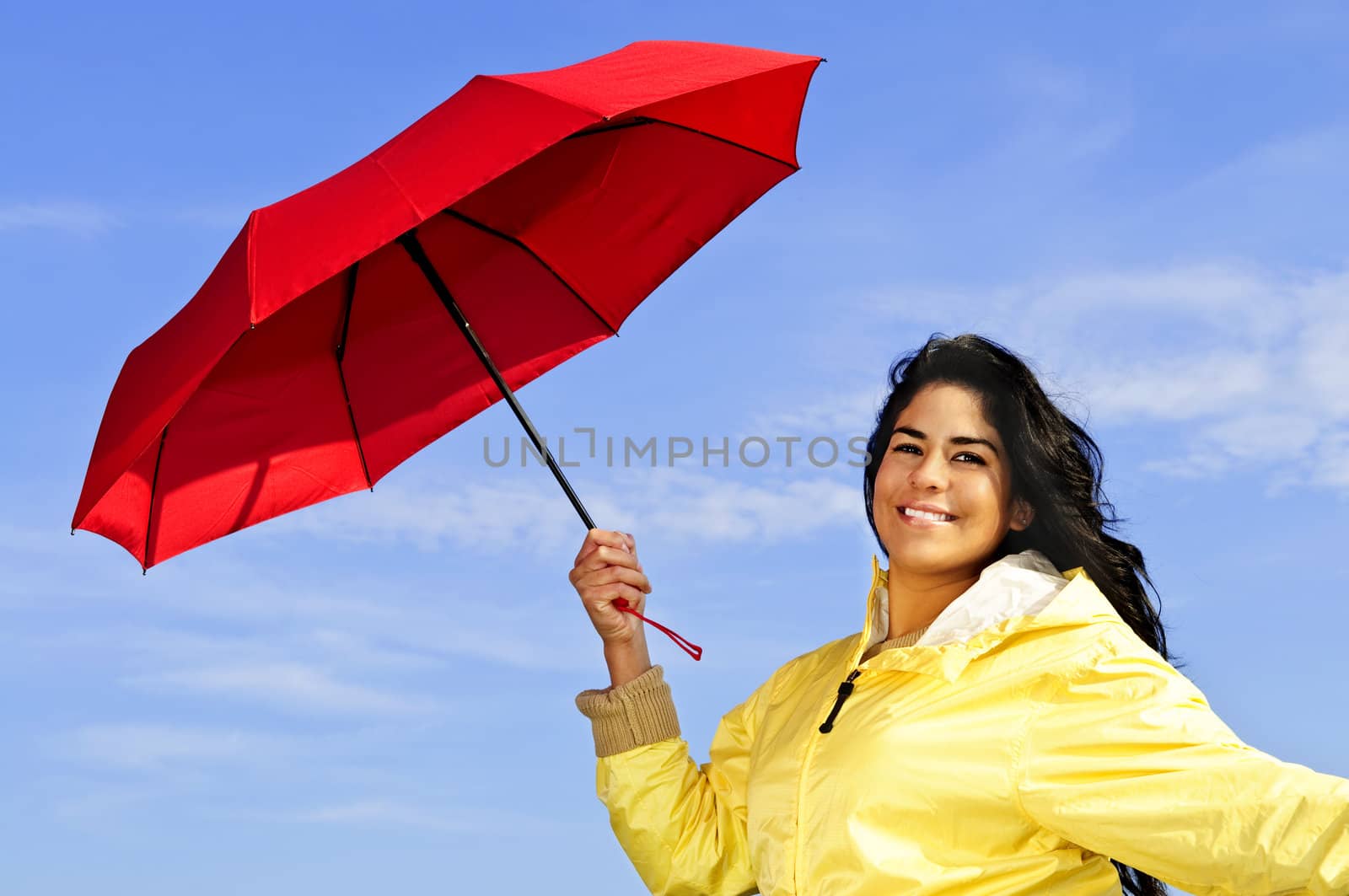 Beautiful young woman in raincoat with umbrella by elenathewise