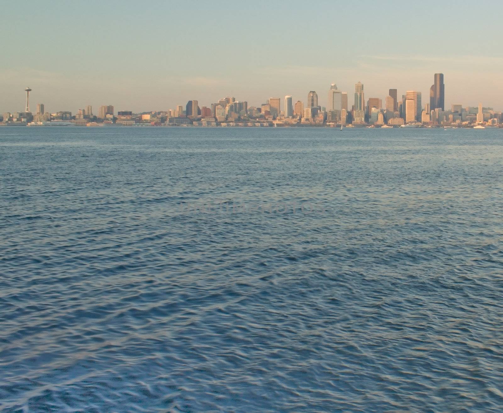 Seattle Skyline with Space Needle and Ferry as it crosses the waters of the Puget Sound as viewed from Alki.