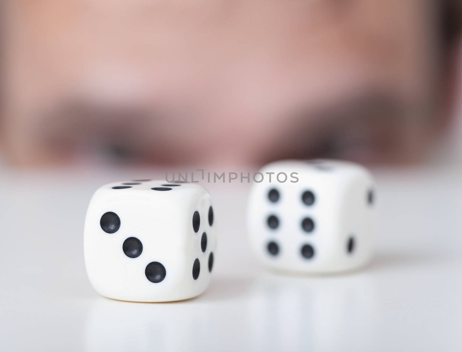 Two white playing cubes against a man face