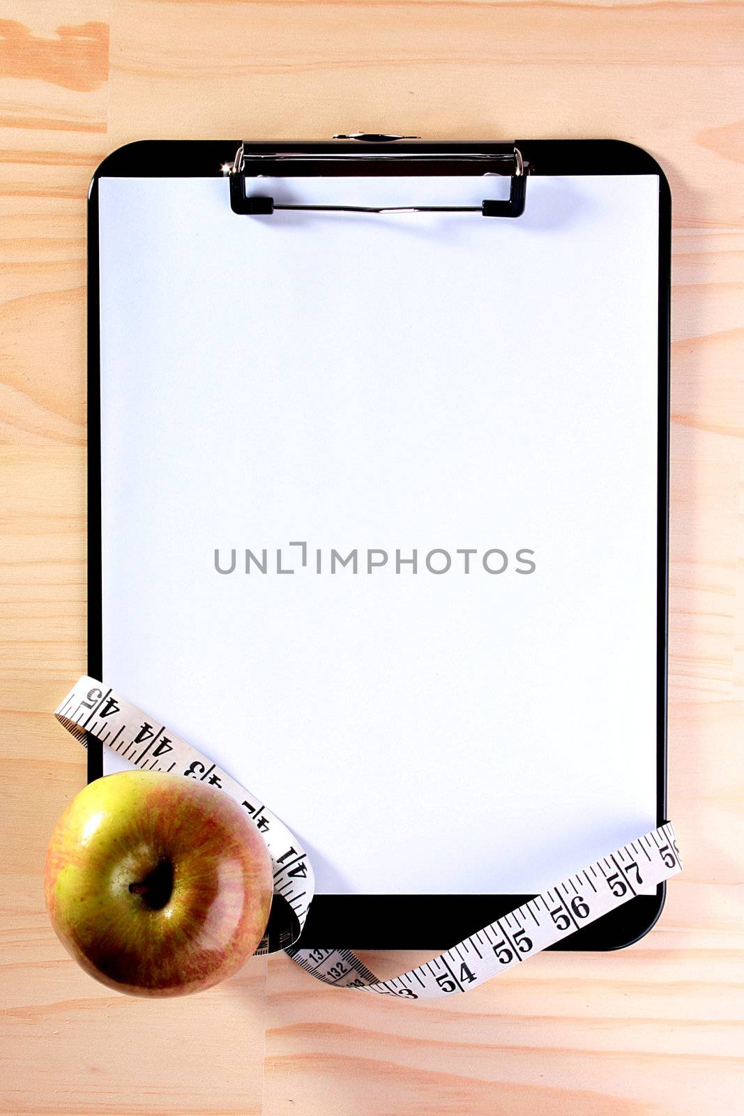 The apple, tape measure and blank clipboard for those who takes a great interest in diets.