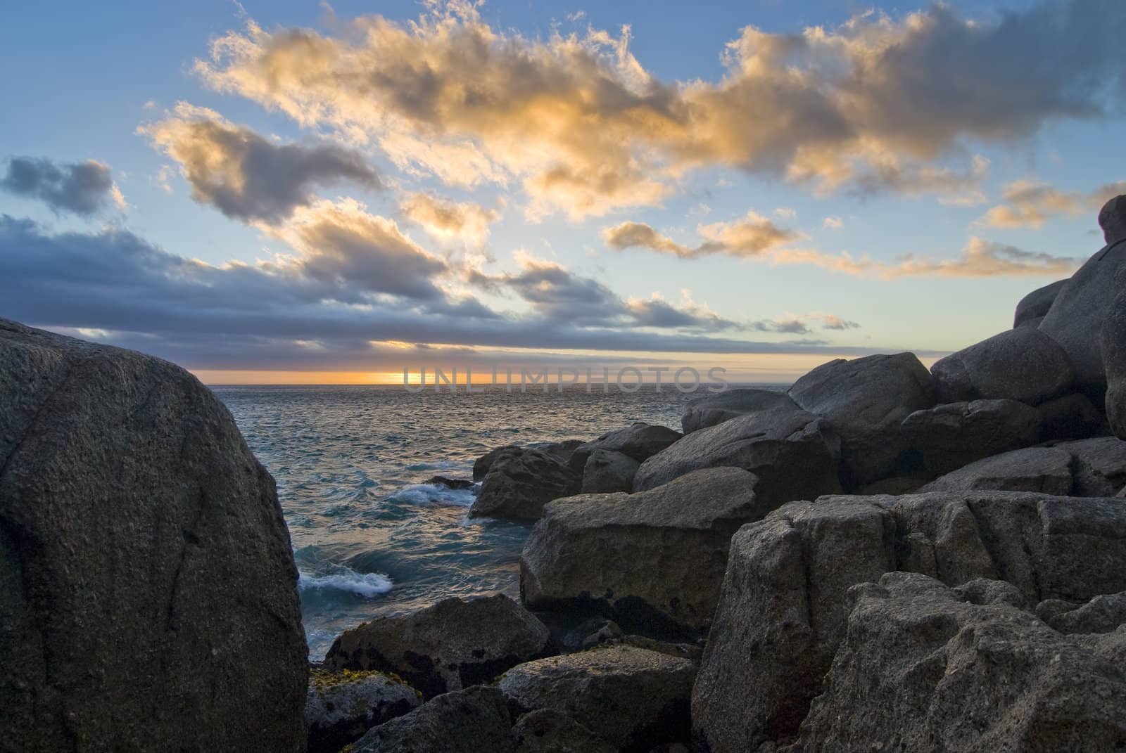 Rocky beach with sunset in the background