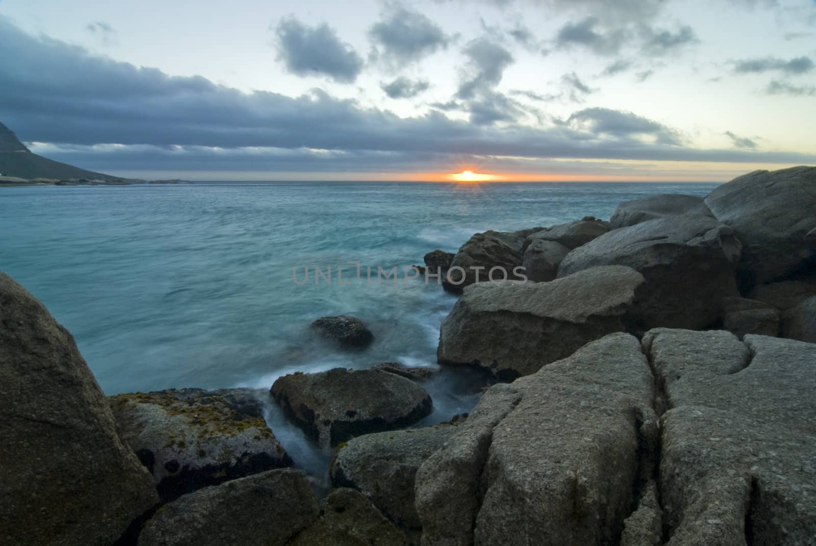 Rocky beach with sunset in the background