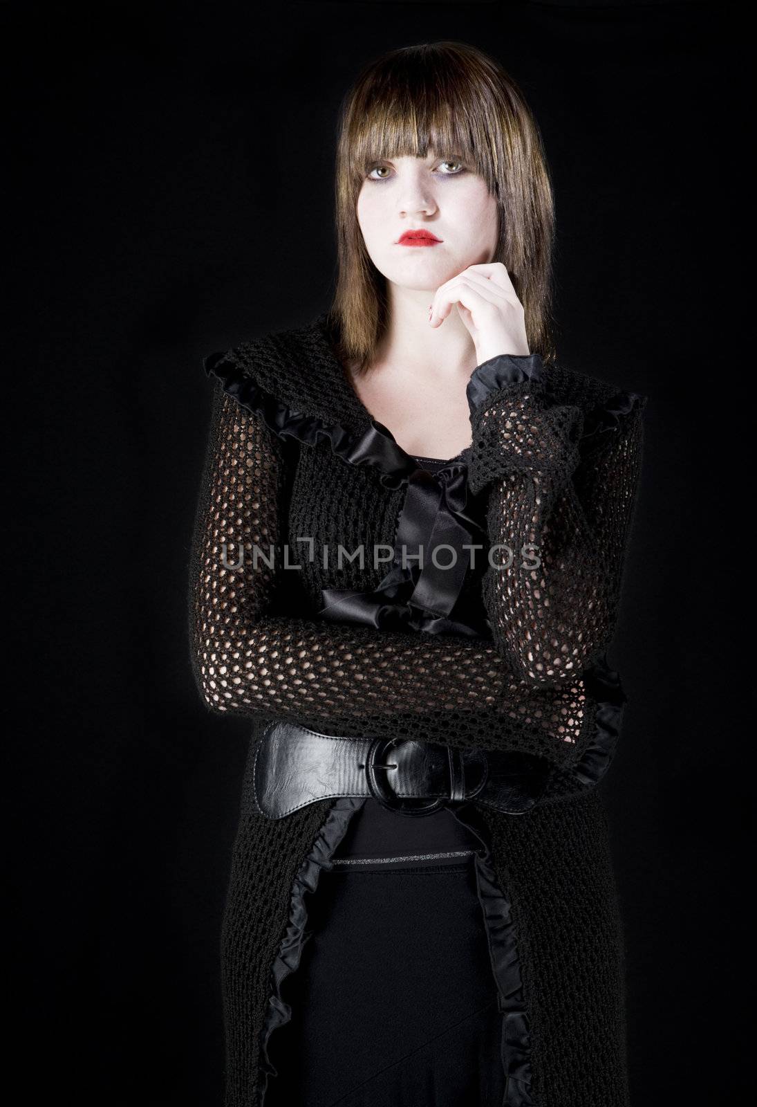 Mysterious young girl with dark makeup dressed in black