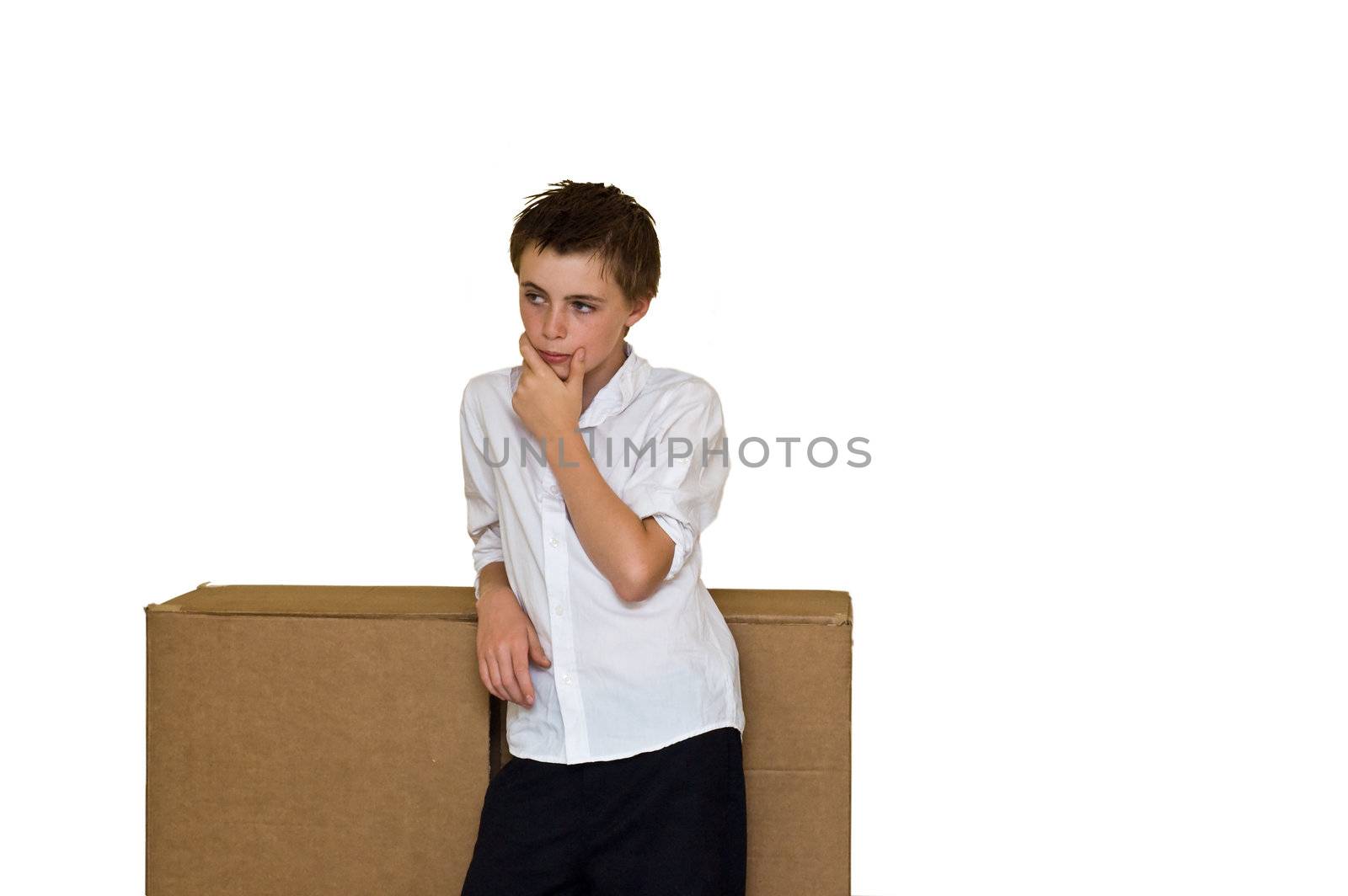 an image of a disheveled young teen stood thinking outside a large cardboard box, depicting the common phrase "thinking outside of the box" isolated for ease of use.