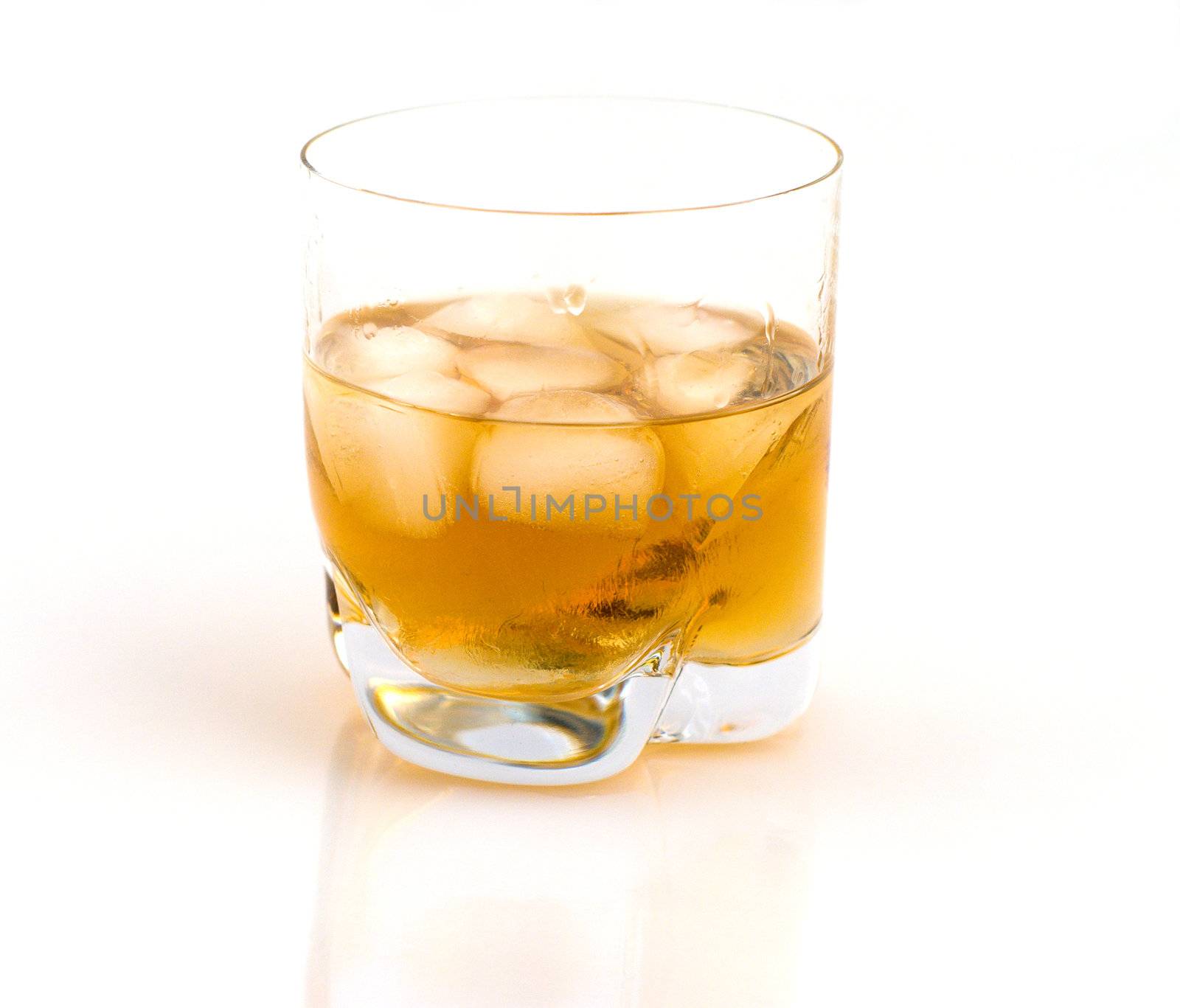 Glass of whisky with ice on a white background.