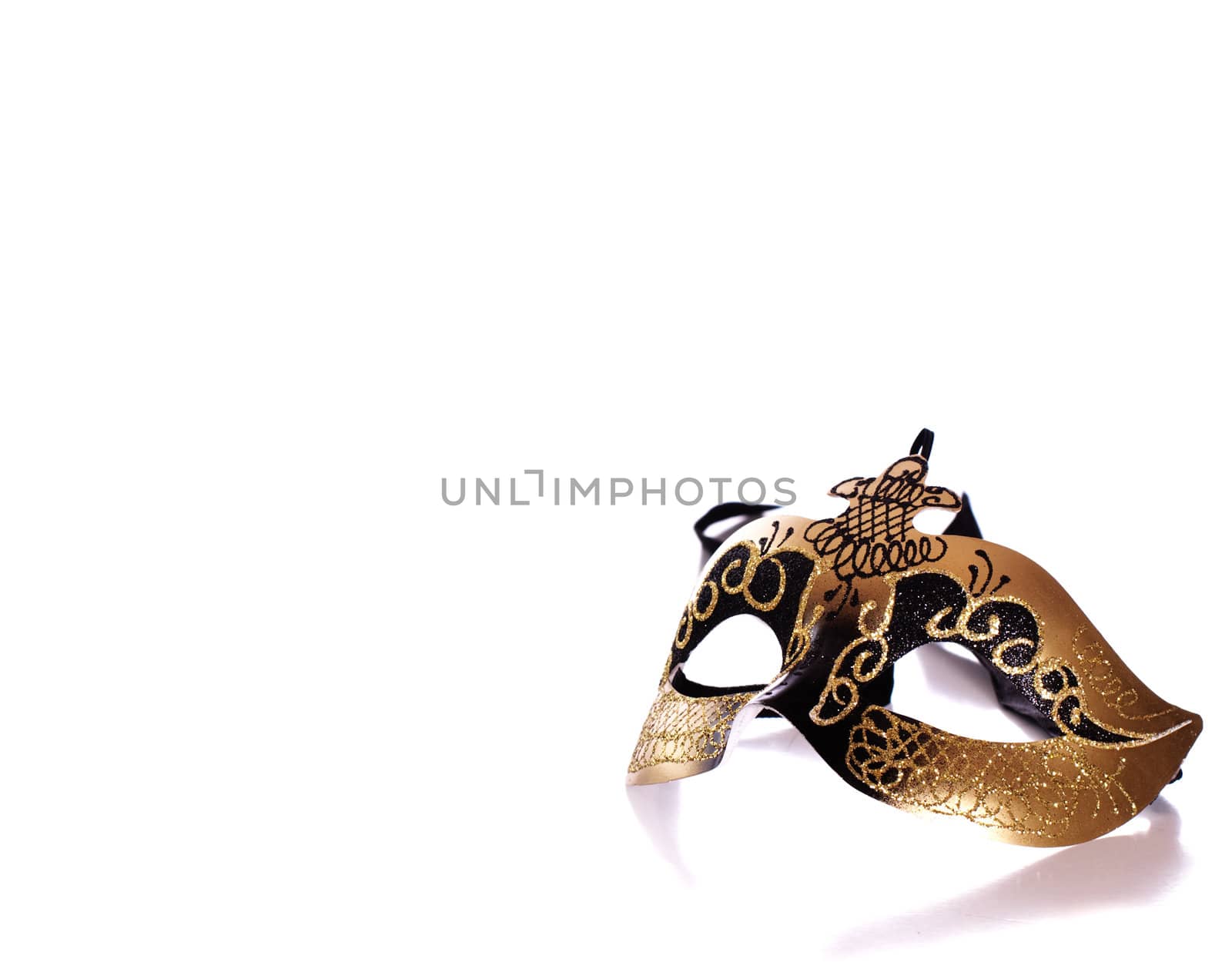 A fancy venetian mask shot against a white background with part of it's reflection in front