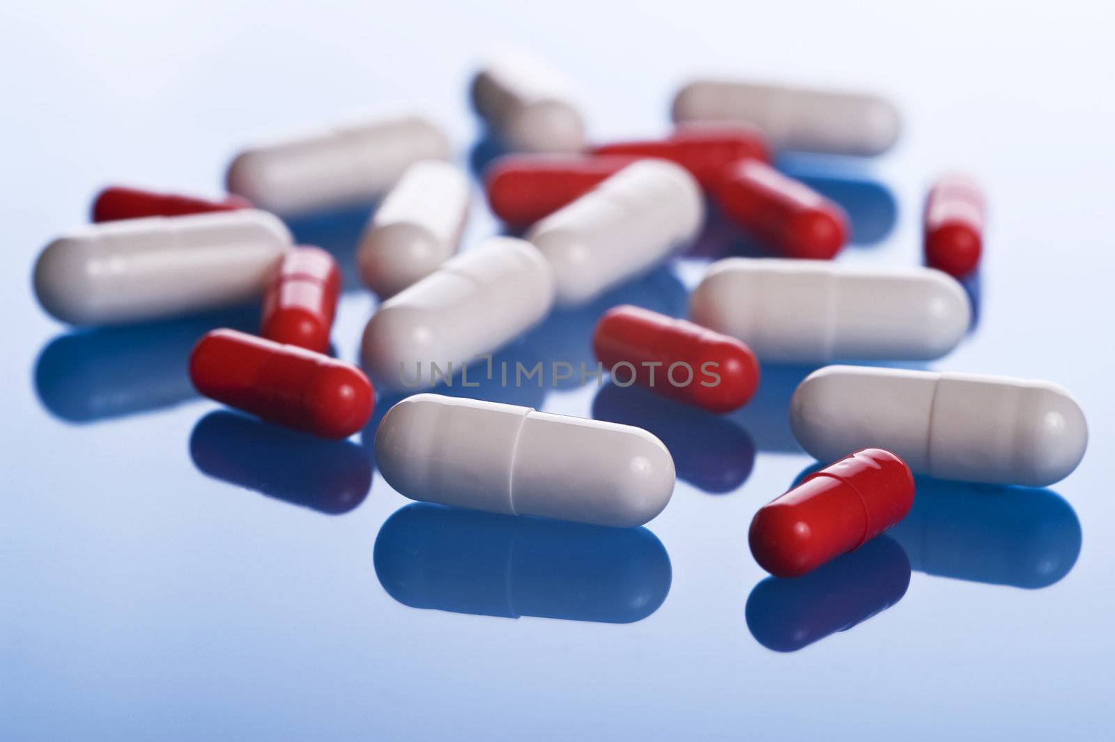 pills scattered on blue background, close up