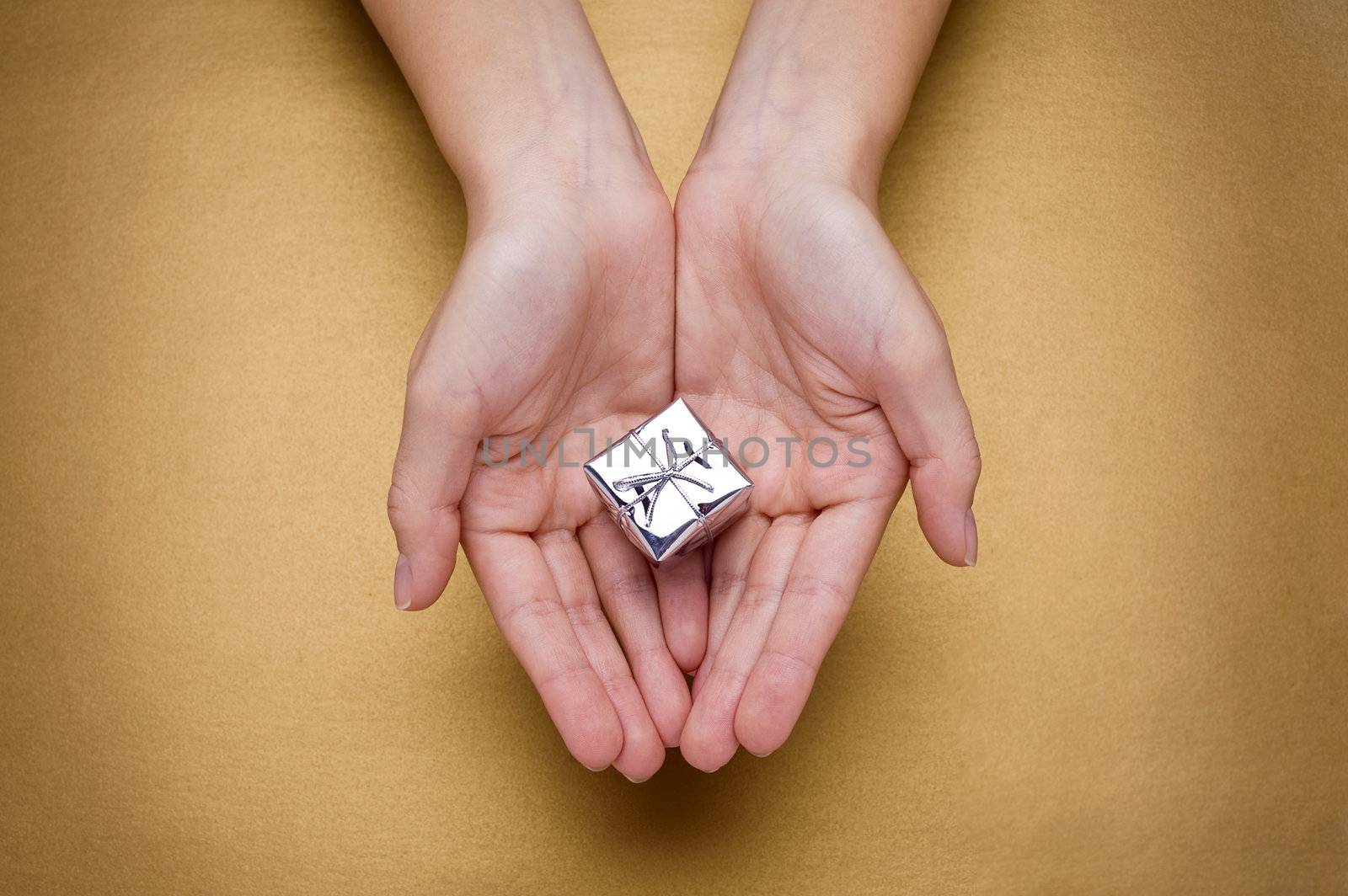 hands giving christmas gift on gold background