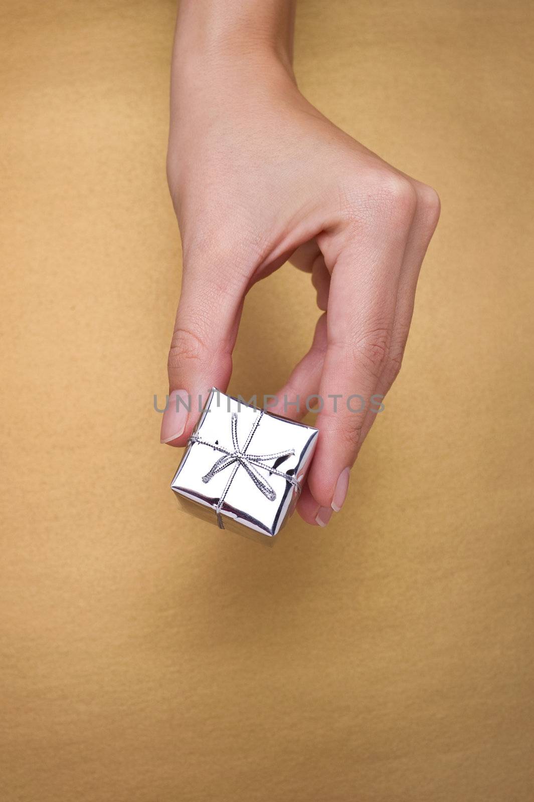 hand giving christmas gift on gold background