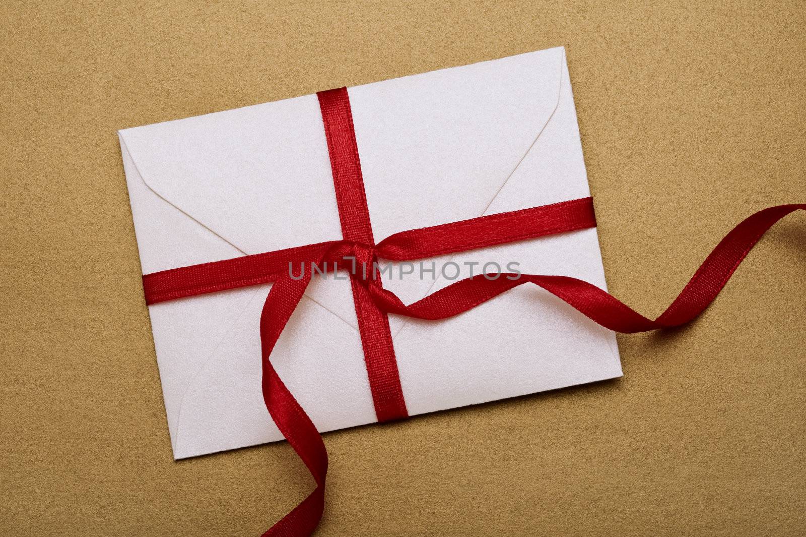 envelope with decorative red ribbon on gold background
