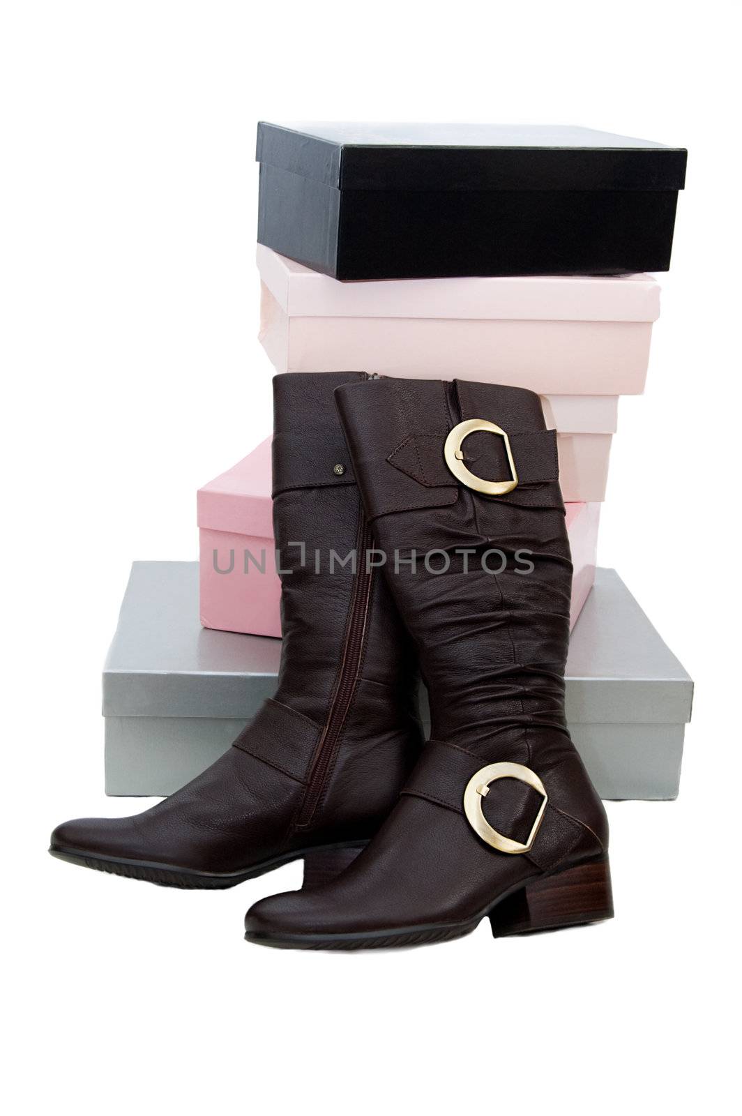 Pair of brown winter woman boots and many boxes over white