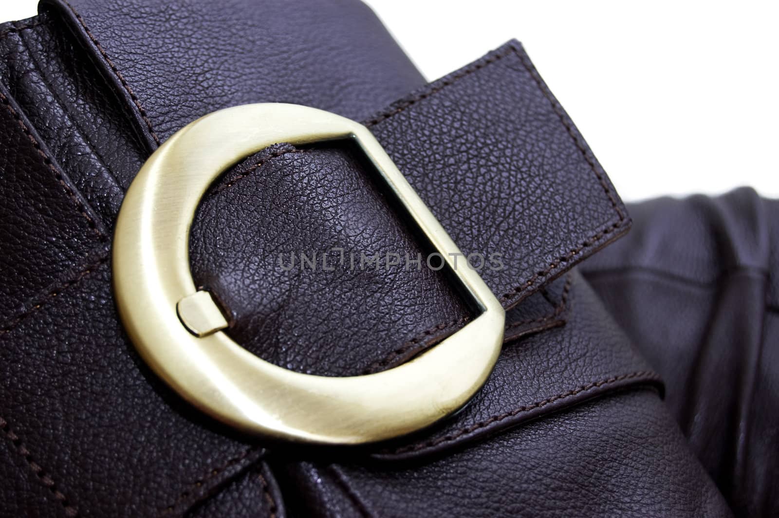 Golden buckle of leather brown boot over white