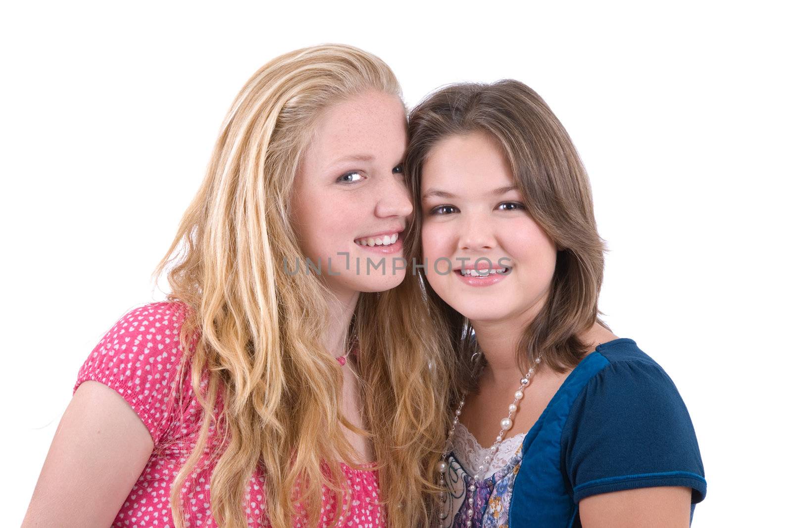 Two cute young teenagers with heads close together on white background