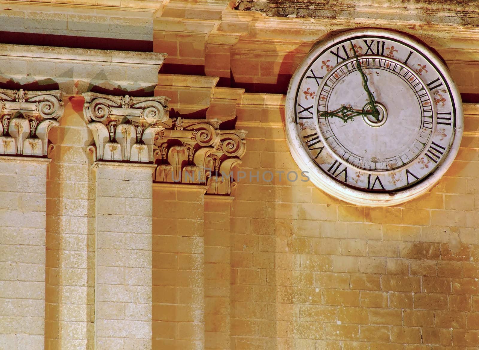 Detail of intricate medieval baroque architecture - detail of stonework and clock dial on Mdina cathedral in Malta