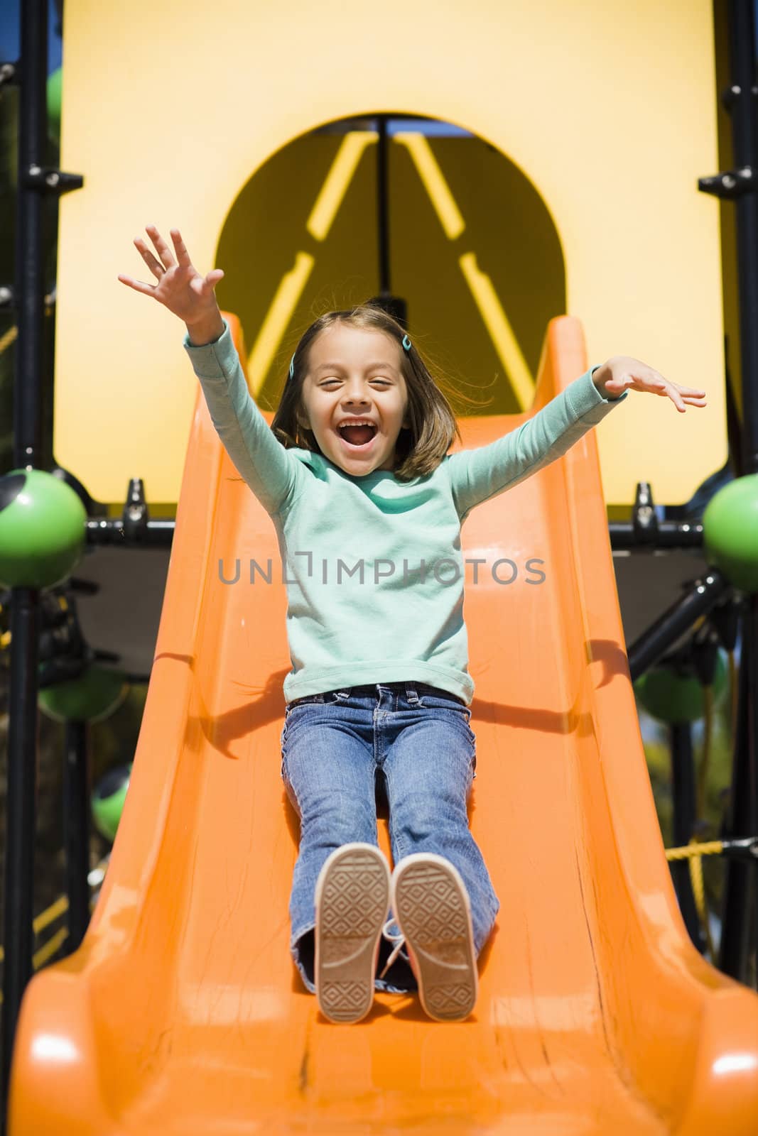 Smiling Young Girl in Park on a Slide