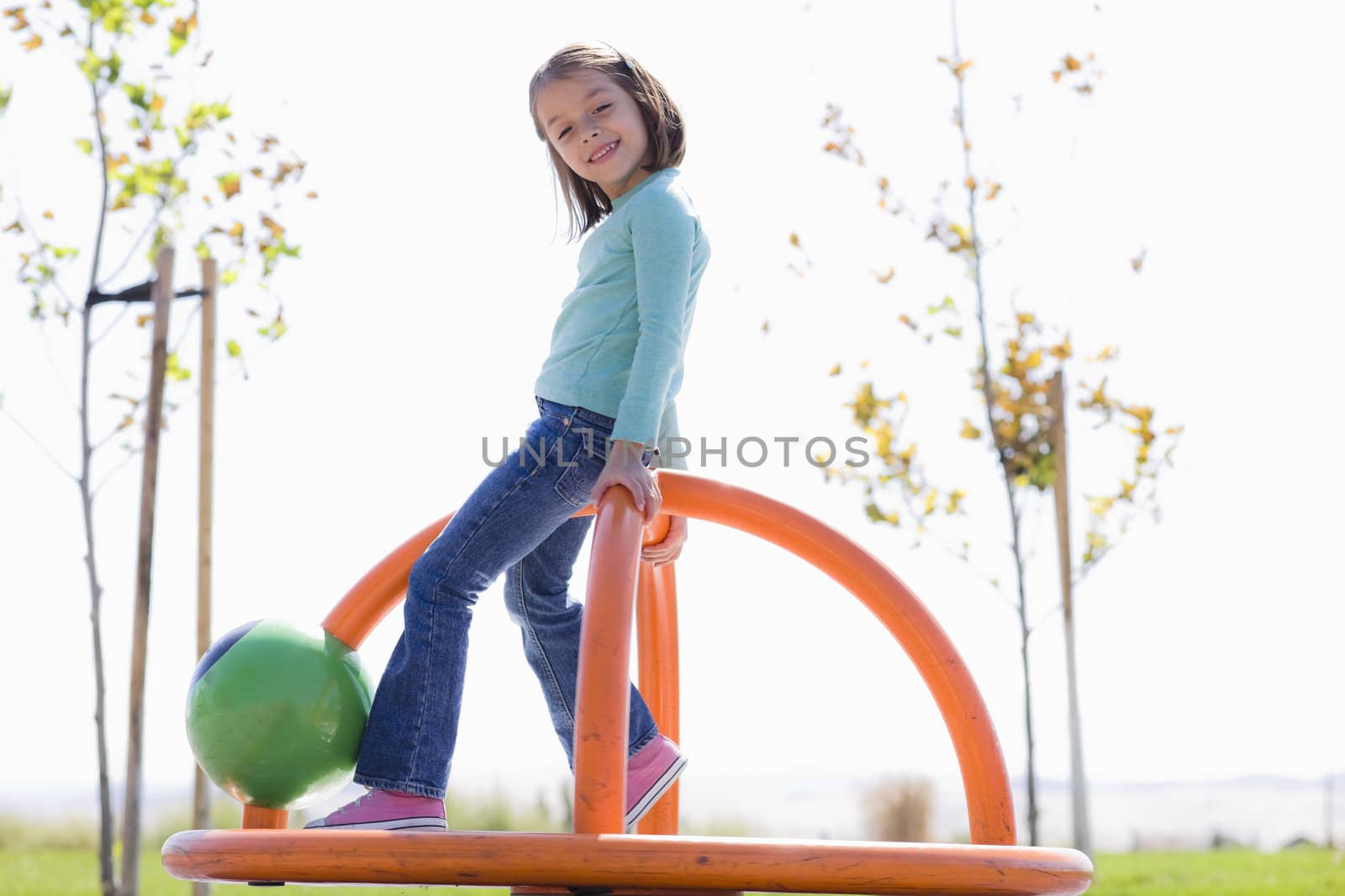 Young Girl Spinning in Playground in a Park