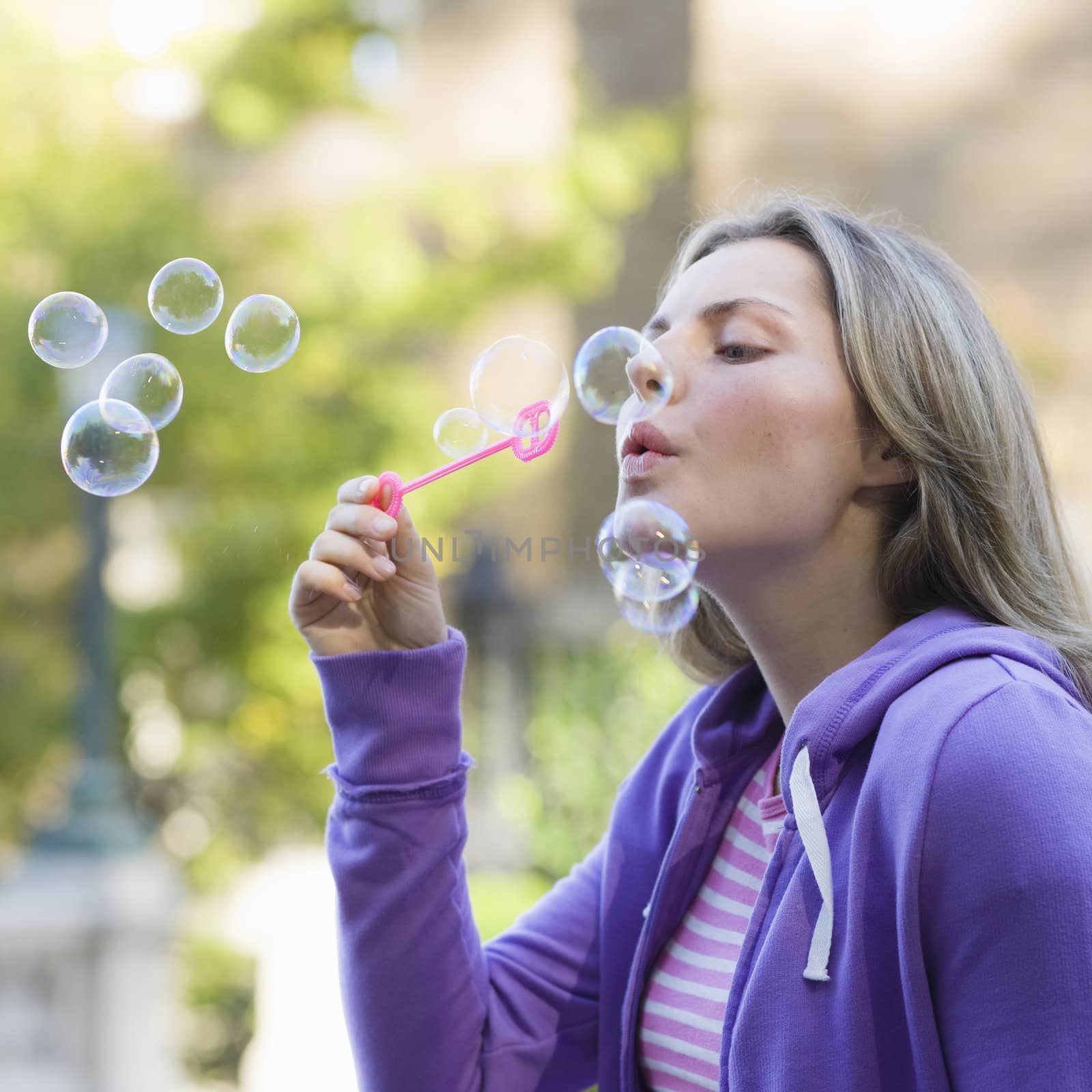 Teen Girl Blowing Bubbles by ptimages