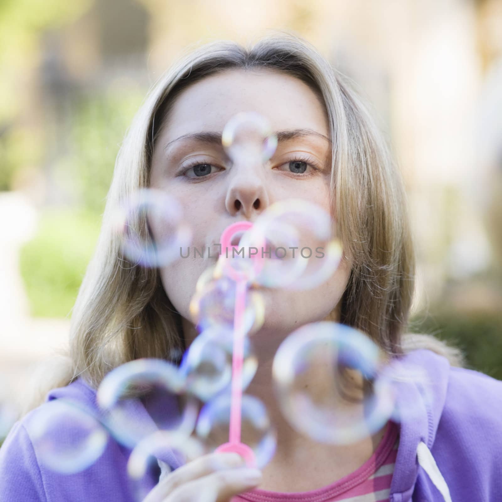 Portrait of a Pretty Blond Teen Girl Blowing Bubbles