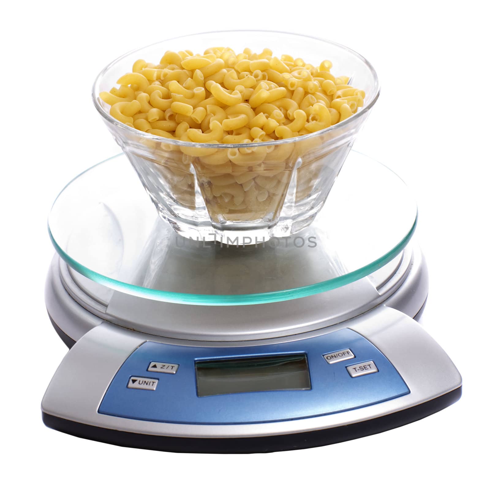A bowl of uncooked macaroni full of carbohydrates, sitting on a food scale, isolated against a white background
