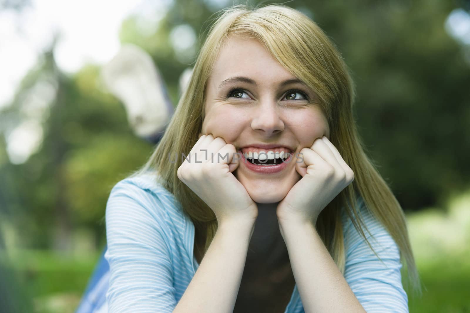 Smiling Teen Girl in Park Looking Away From Camera