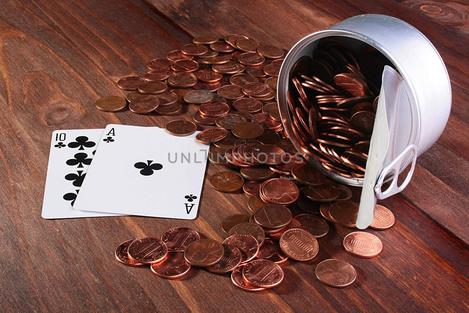 Cents USA are poured out from a can on a wooden table both two cards an as and 10, make 21.