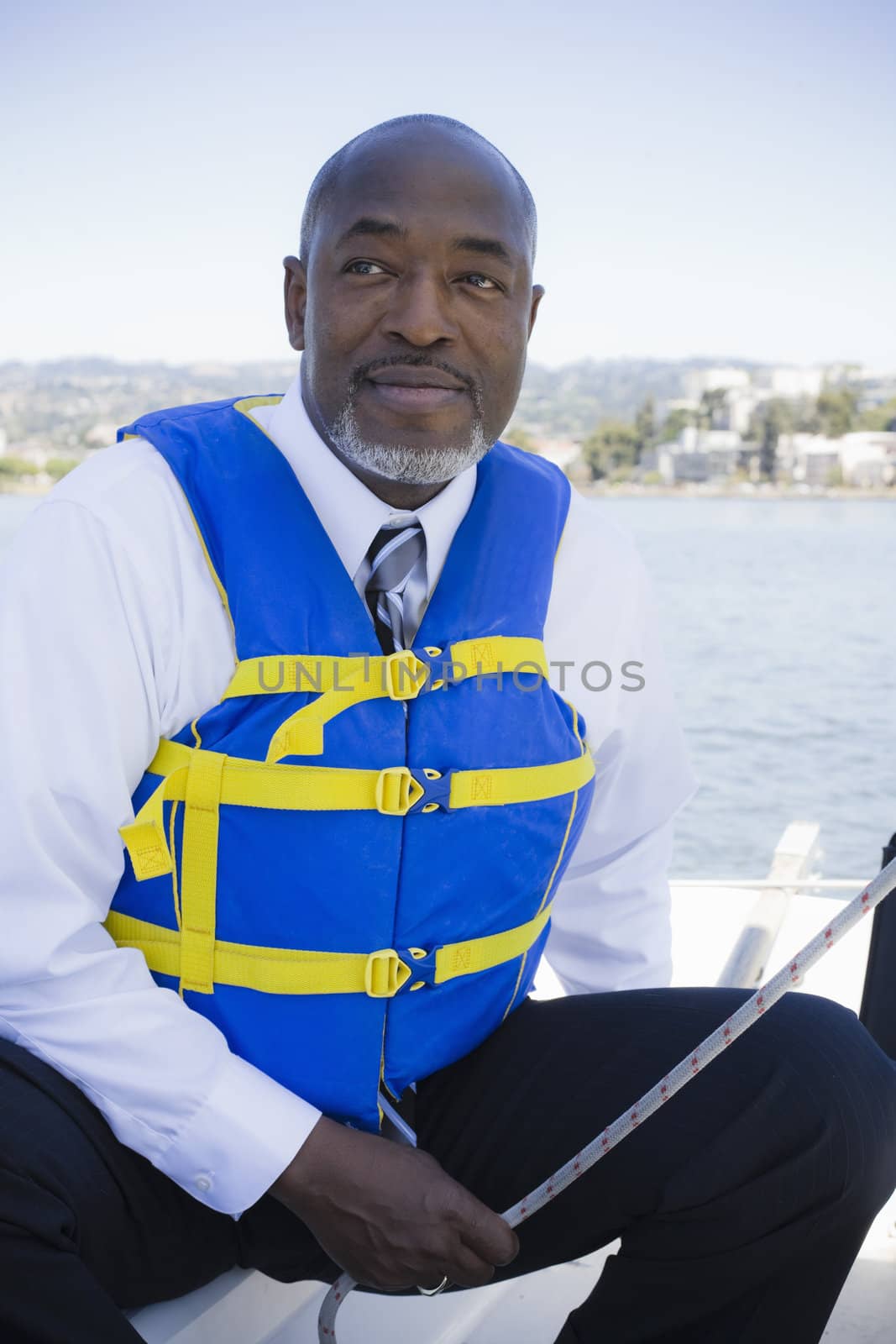 African American Man in Life Vest Sailing a Boat