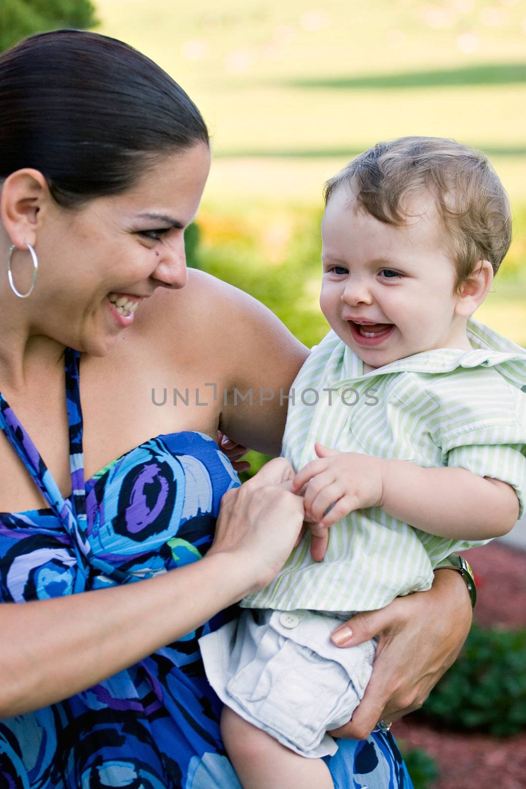 A young mother tickles her baby happily.