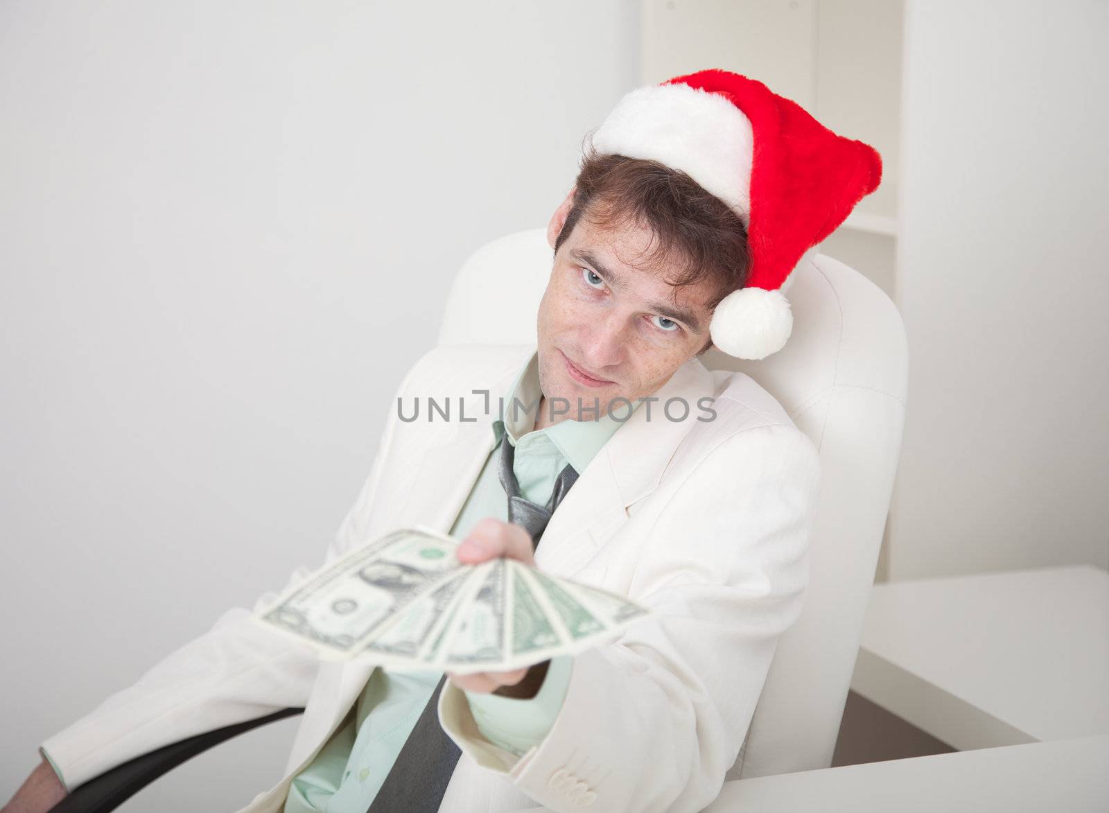 The businessman in a white suit and a Christmas cap gives us money